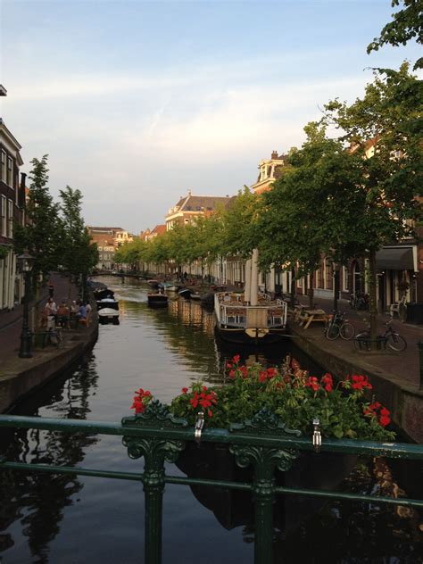 a canal that has some boats on it and flowers in the water next to ...