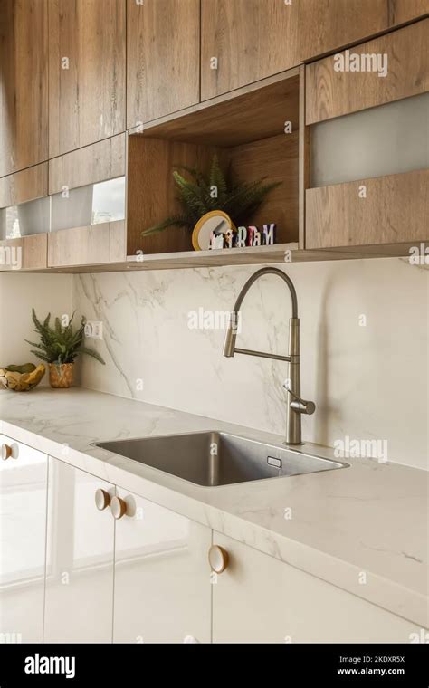 Sink with faucet on marble counter in light modern kitchen of apartment ...