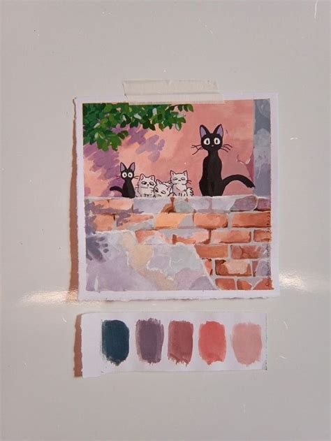 two cats sitting on top of a brick wall next to a tree and some paint ...