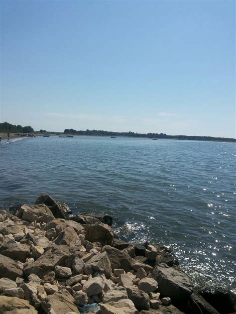 the water is crystal blue and there are rocks on the shore