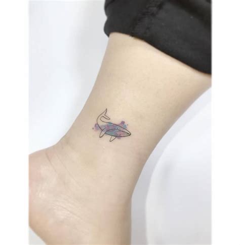 Little whale tattoo located on the ankle.