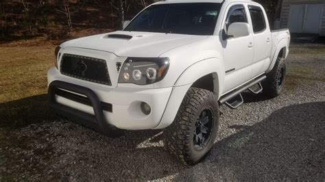 a white truck is parked in the gravel