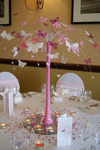 the centerpiece is decorated with pink and white paper butterflies ...