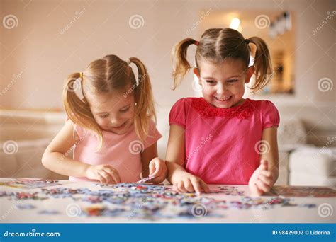 Girls playing puzzle stock photo. Image of childhood - 98429002