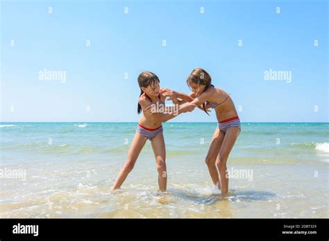 Two girls fight on the sandy beach of the sea Stock Photo - Alamy