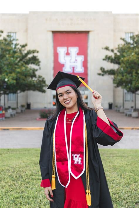 a woman in a graduation gown and cap is posing for the camera with her ...