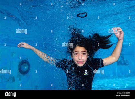 Young girl of 9 holds her breath while floating underwater in a swimming pool Stock Photo - Alamy