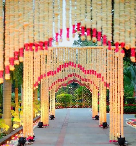 an archway decorated with red and white flowers in the middle of a ...