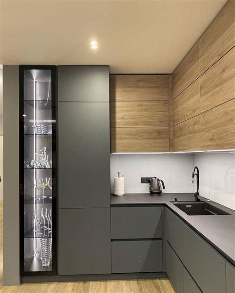 a modern kitchen with wooden cabinets and stainless steel counter tops, along with glass shelves