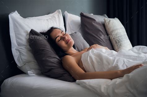 hotel, travel and happiness concept - beautiful woman sleeping in bed ...