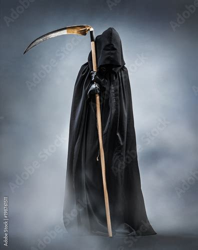 Grim Reaper standing in the fog at night. Photo of personification of death wielding a large ...