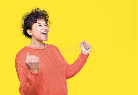 Happy Black Woman Celebrating Success with Clenched Fists on Yellow ...