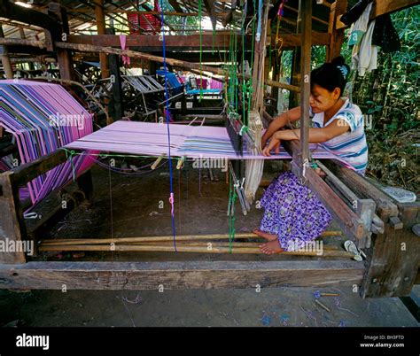 Young Kayin girl weaving traditional pattern on a loom Junge Karen Frau webt traditionelle ...