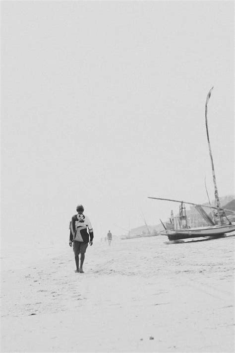 Man Walking on Beach in Black and White · Free Stock Photo