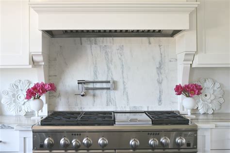 White kitchen with Danby Marble slab backsplash behind Monogram range ...