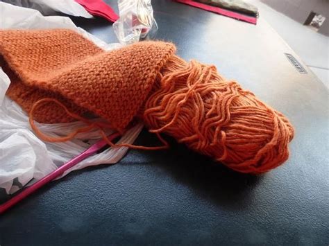 Orange yarn complete with a hook. Crocheting and other fiber arts are ...