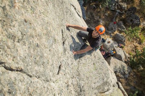 Adventurers climbing mountain, wearing safety harness against picturesque landscape — hobby ...