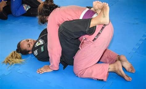 two people in pink shirts are wrestling on blue mats and one person is ...