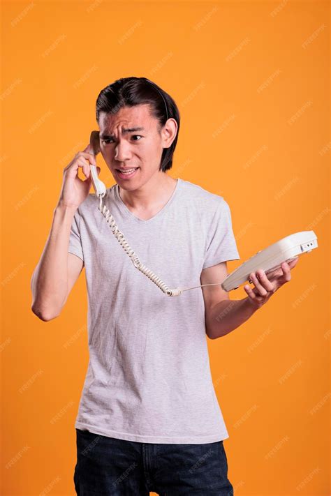 Premium Photo | Young angry man talking on landline phone. irritated ...