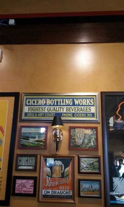 there are many framed pictures on the wall in this restaurant that is decorated with beer signs