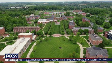 an aerial view of a college campus with trees and grass in the foreground, surrounded by buildings