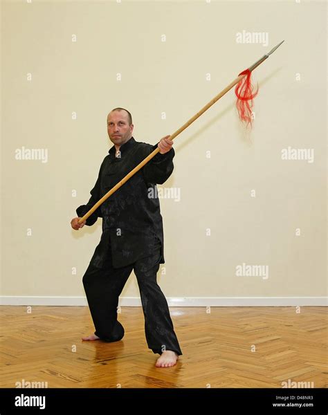 Man posing in a martial arts stance with a ceremonial spear Stock Photo - Alamy