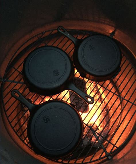 Hand seasoning cast iron skillets over open fires in the backyard ...