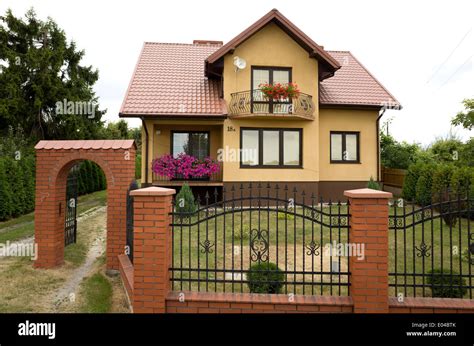 Modern Polish house with wrought iron fence with brick pillars and arch. Rzeczyca Central Poland ...