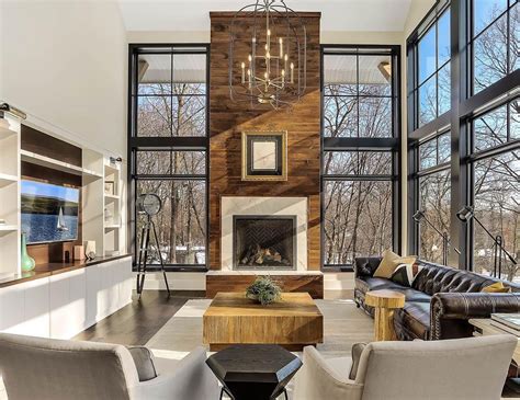 Modern Living Room Features Towering Fireplace Among Floor to Ceiling Windows | Pella
