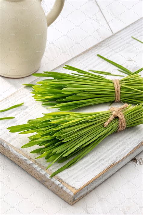 Freshly grown barley grass on a white wooden table. Food photography healthy natural vegetarian ...