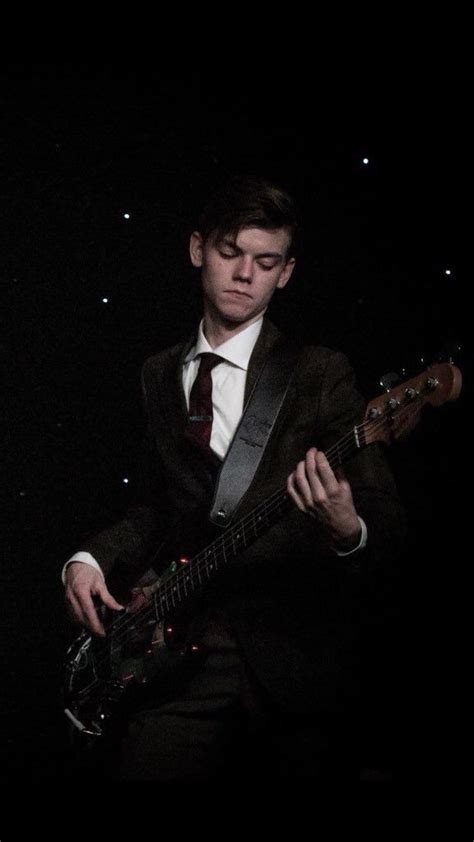 a man in a suit and tie playing an electric guitar at night with stars ...