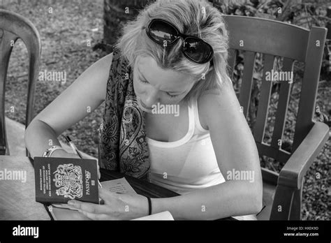 female traveller abroad using uk passport to fill out form Stock Photo - Alamy