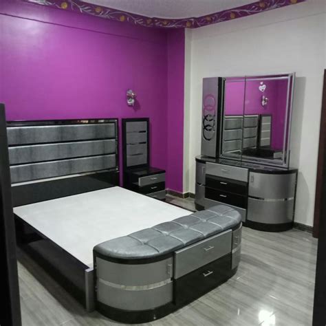 a bedroom with purple walls and black furniture