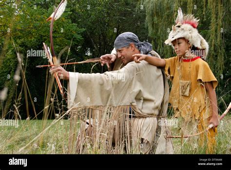 Native American Indian man with a bow and arrow hunting with a boy ...