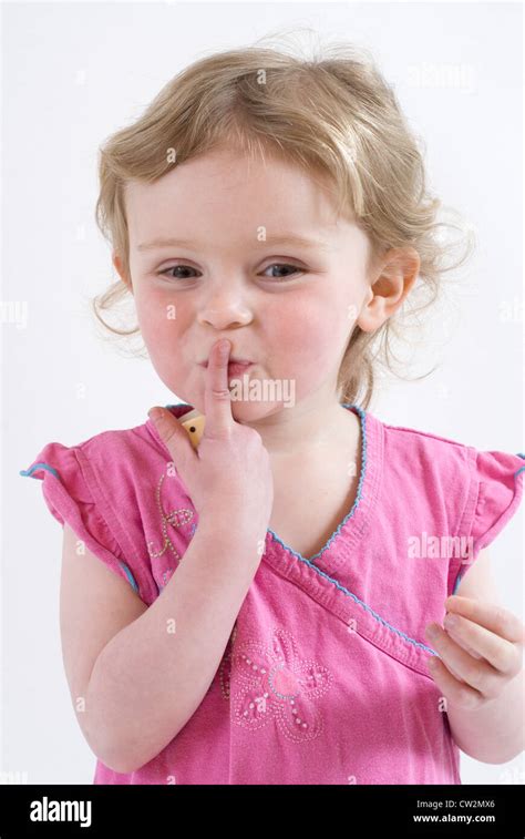 Sshhhhhh! Cute Little Girl Holding up finger to her mouth in Shushing Gesture, Studio Portrait ...