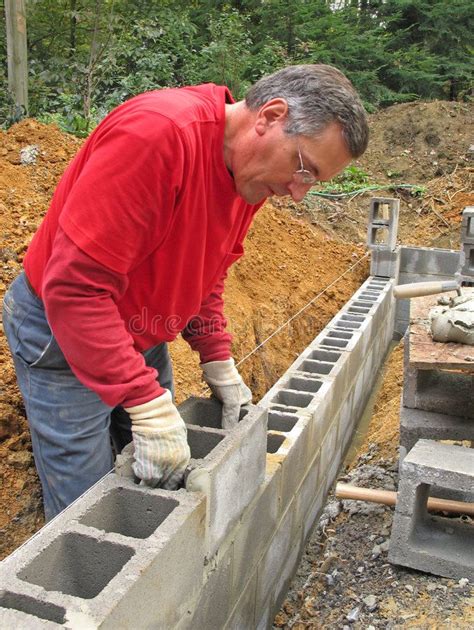 Man laying concrete block wall. Man laying concrete block foundation ...