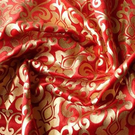 a red and gold fabric with an intricate design