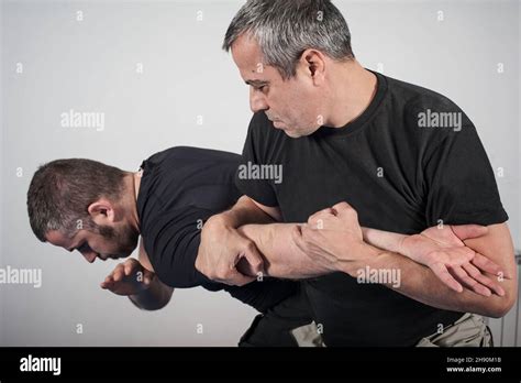 Kapap instructor demonstrates arm bar techniques with his student Stock ...