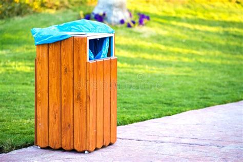 Yellow Wooden Trash Can Outdoors on the Side of Sidewalk in Park. Garbage Container on Street ...