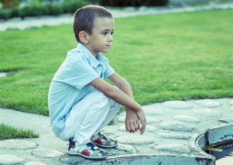 A Sad Boy is Sitting on the Street Alone. Unhappy Lonely Child. Blue ...