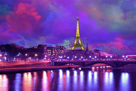 Eiffel Tower at night against a dramatic sky’ - Pickawall