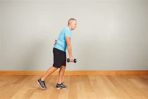 an older man is doing exercises with dumbbells