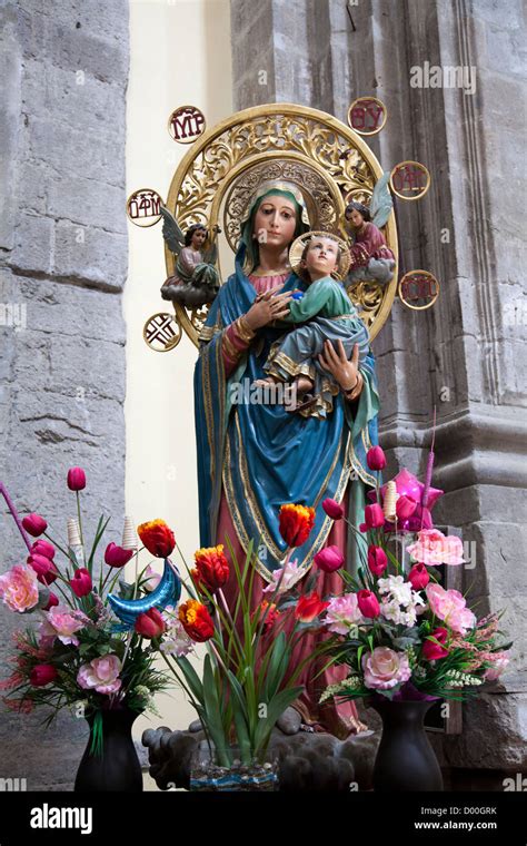 Virgin Mary Holding Baby Jesus Statue and Flowers Stock Photo - Alamy