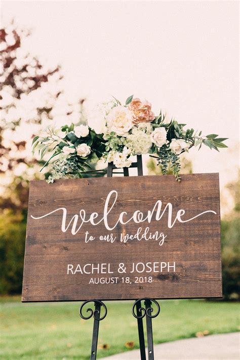 a welcome sign with flowers and greenery is displayed in front of a ...