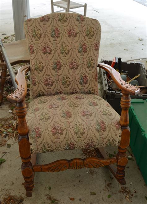 an old chair is upholstered with floral fabric