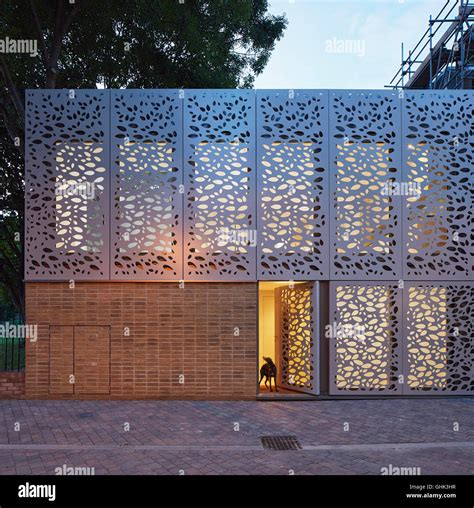 Front elevation of entrance facade with metal screen at dusk. House in Brixton, London, United ...