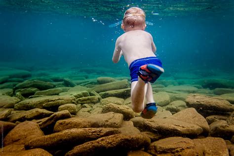 "Little Boy Swimming Underwater In Clear Lake In Summer On Vacation" by Stocksy Contributor "JP ...