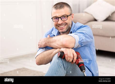 Mature Man Assembling Furniture Sitting Posing With Electric Drill Indoor Stock Photo - Alamy