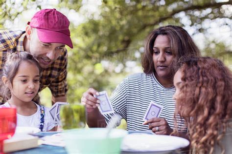 Family playing cards at campsite - Stock Photo - Dissolve