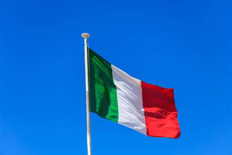 Italy flag. Italian flag on a pole waving on blue sky background ...